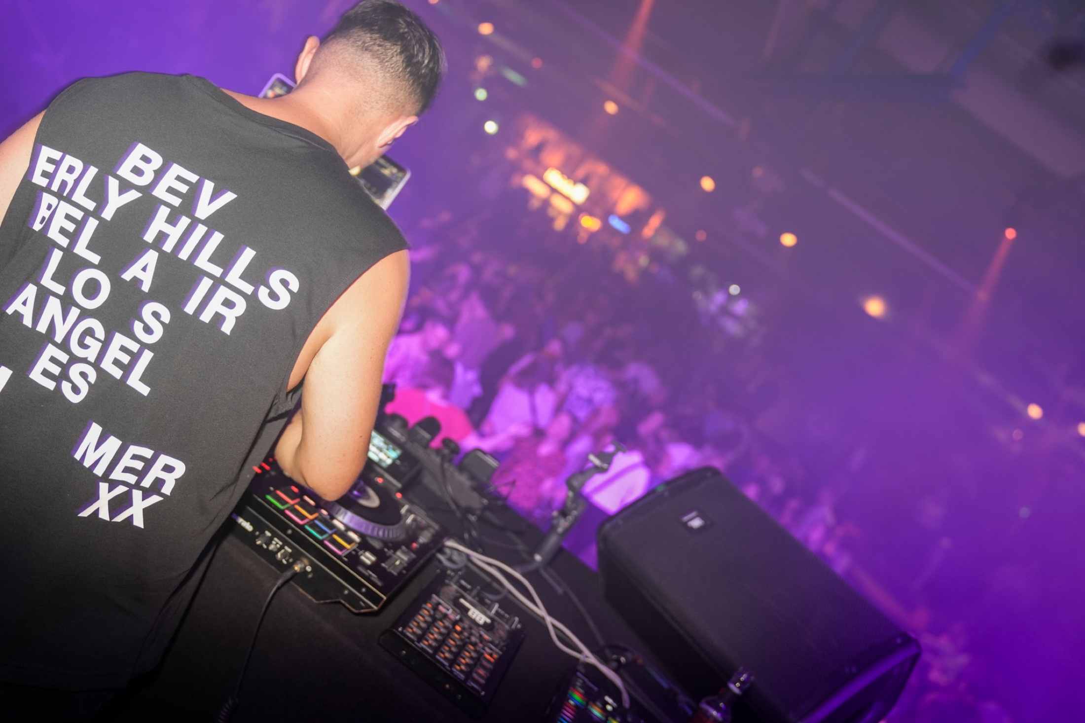 DJ Raff mit Blick auf eine violett beleuchtete Crowd