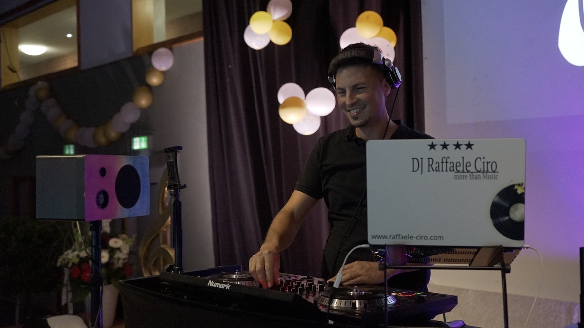 DJ Raff lächelnd am Mischpult